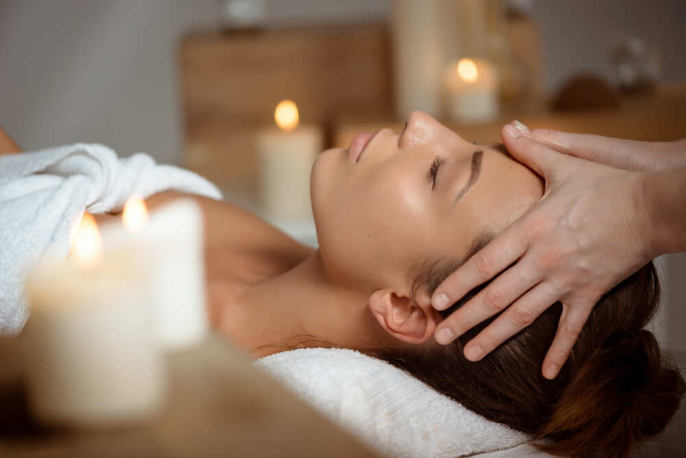 jeune-femme-ayant-massage-du-visage-relaxant-dans-salon-spa